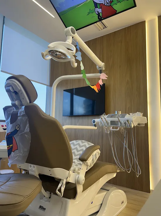 Cadeira odontológica do consultório com TV no teto